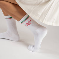 White socks with red and green accents worn by a person on a light background